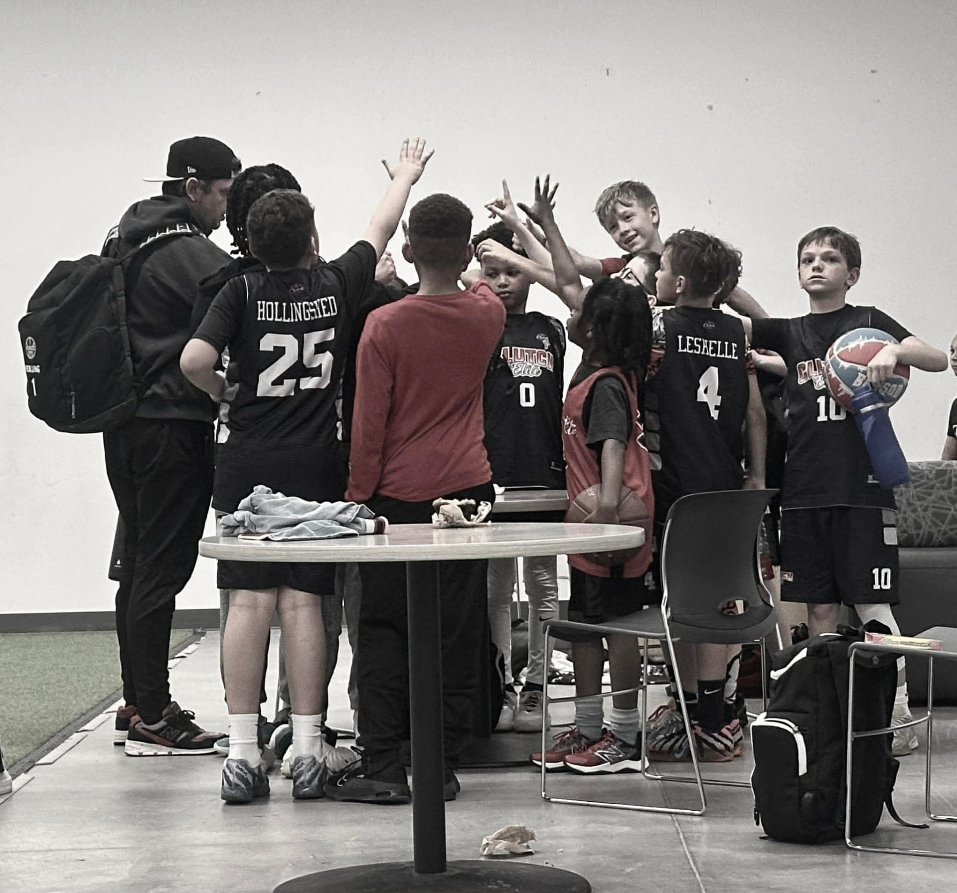 Clutch Elite team huddle with hands raised